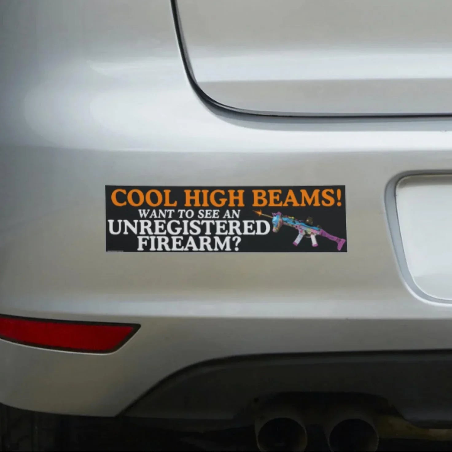 Funny bumper sticker on car with bold text and a colorful illustrated firearm graphic.