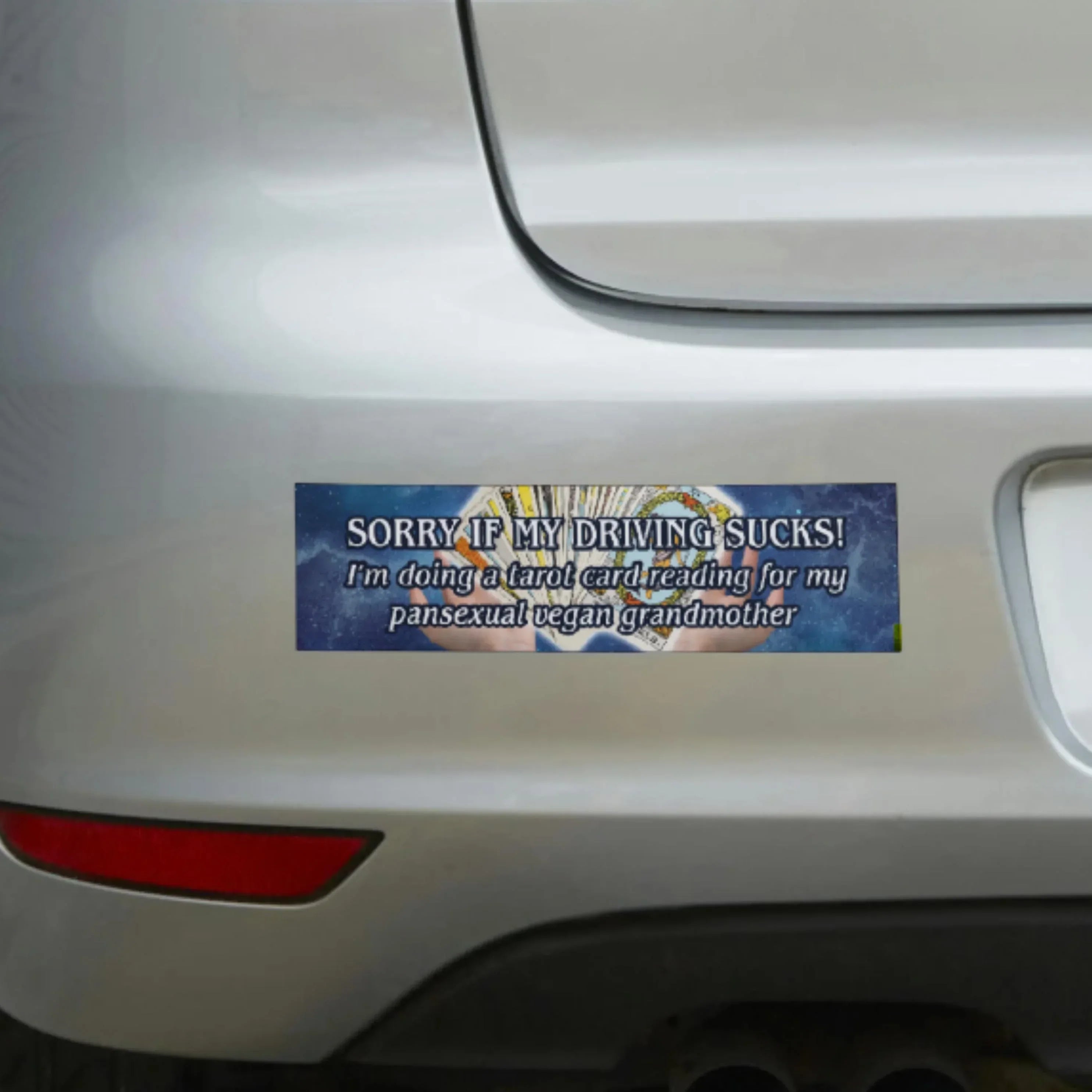 Funny tarot card bumper sticker on car, reads: 'Sorry if my driving sucks!'