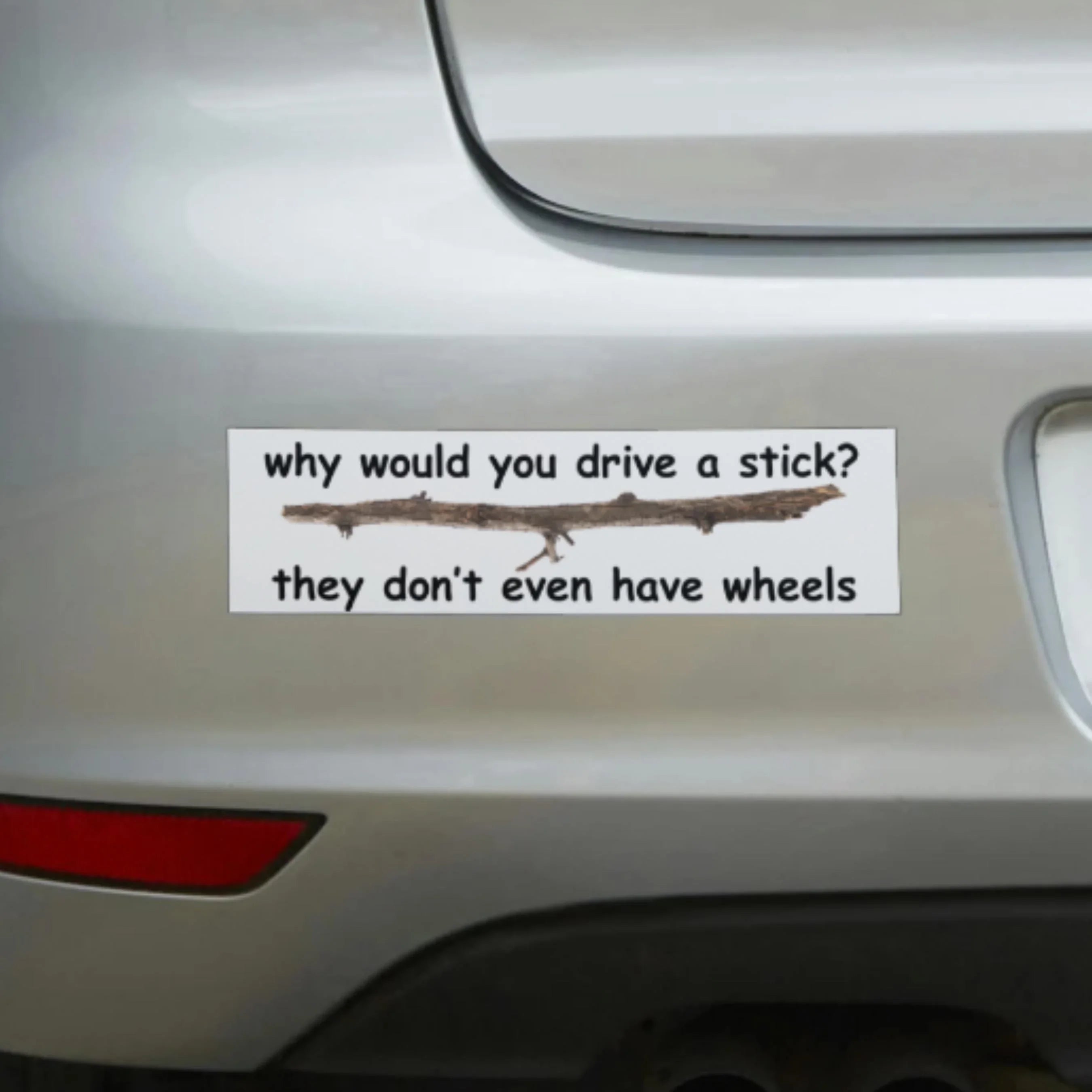 Funny vinyl bumper sticker on car with stick graphic and text joke about driving a stick.