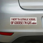 Humorous weatherproof bumper sticker on car reading 'I went to Catholic school of course I'm gay'.