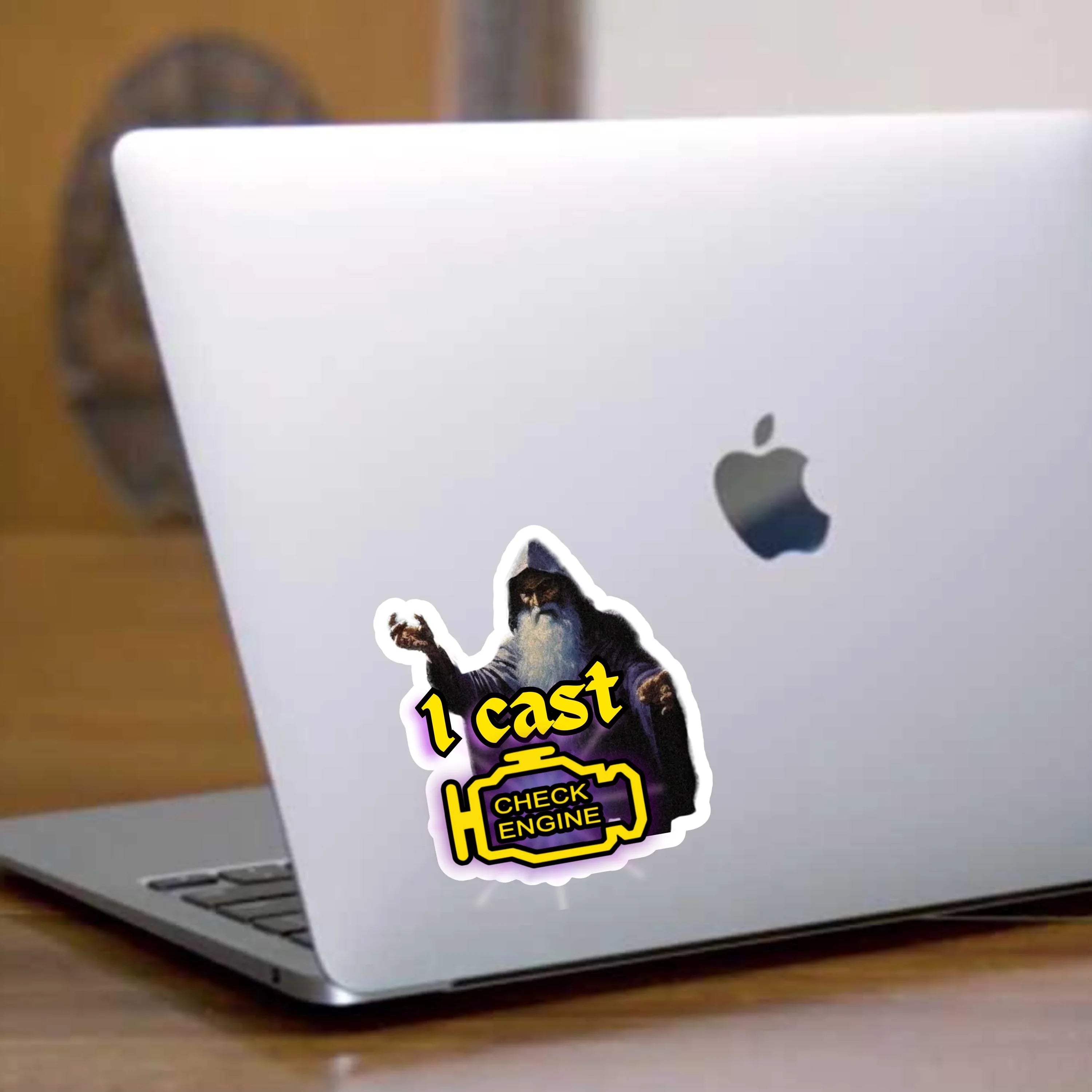 Wizard sticker with '1 cast CHECK ENGINE' on laptop, bold and weatherproof design