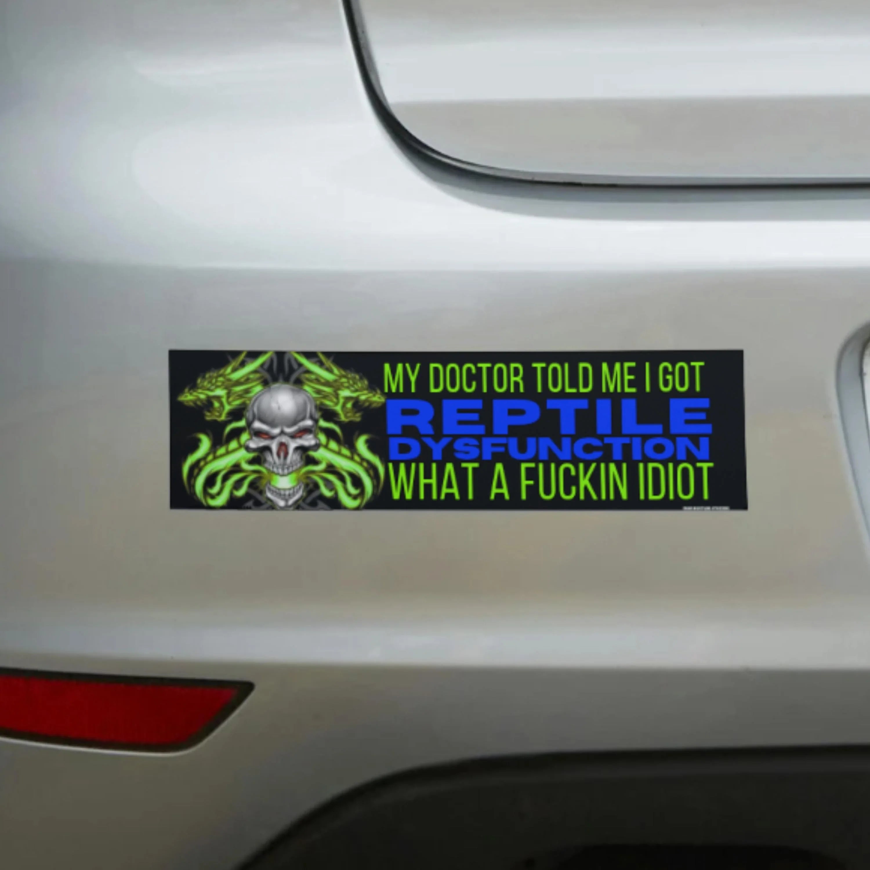 Edgy bumper sticker with skull, green flames, and bold text reading 'Reptile Dysfunction' on white car.