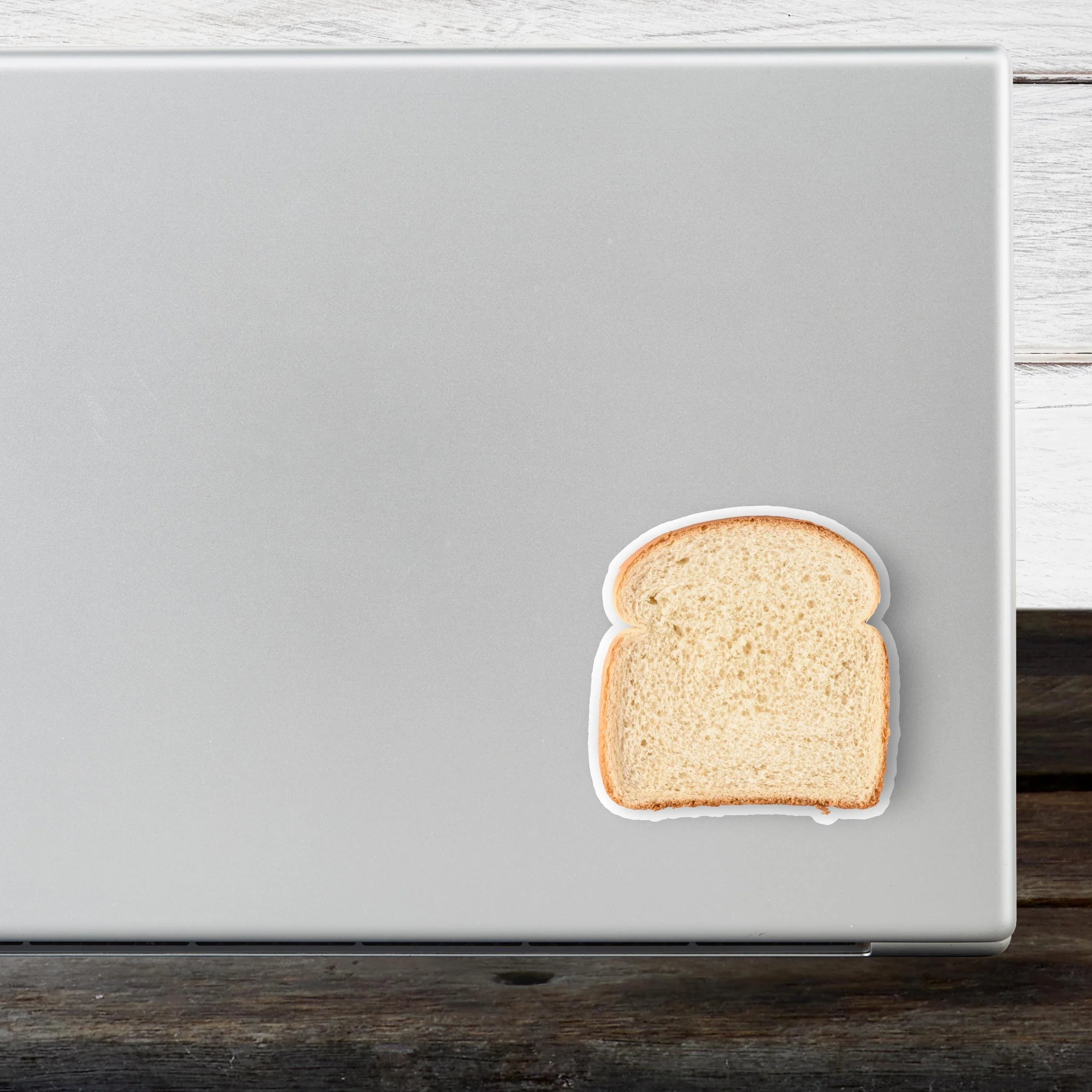 Slice of white bread sticker on silver laptop, weatherproof vinyl design for laptops and bumpers